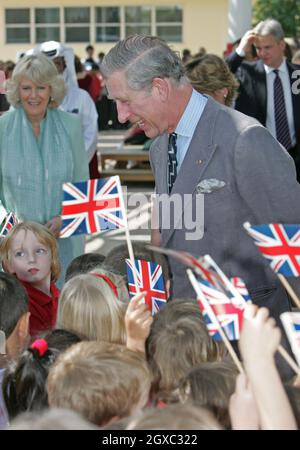 Prinz Charles, Prinz von Wales und Camilla, Herzogin von Cornwall werden von Kindern begrüßt, die den Union Jack winken, als sie am 25. Februar 2007 die englischsprachige Schule in Doha, Katar, besuchen. Stockfoto