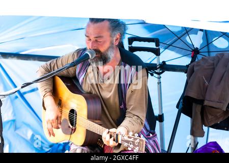 Ein Outdoor-Gitarrist, der am Hafen in Padstow unterwegs ist Stockfoto