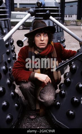 Doktor, der Schauspieler Tom Baker mit seinem fiktiven Feind, den Daleks, um 1975 posiert Stockfoto