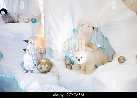 Weihnachtliche Einrichtung. Eisbären und Pinguine auf einem künstlichen Eisberg in einer Höhle Stockfoto