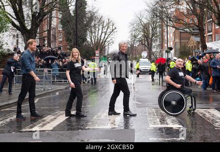 Prinz Harry, Herzog von Sussex, überquert in Begleitung von Jon Bon Jovi und Mitgliedern des Invictus Games Chors die legendäre Zebrakreuzung der Abbey Road in den Abbey Road Studios in London, wo am 28. Februar 2020 eine Single für die Invictus Games Foundation aufgenommen wurde Stockfoto