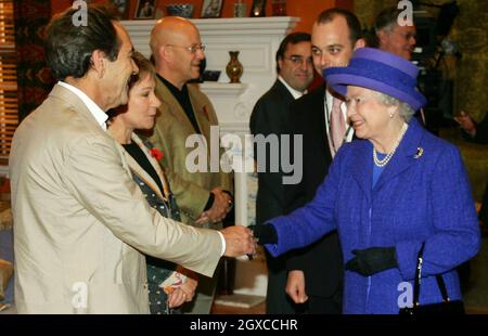 Queen Elizabeth II schüttelt sich die Hände mit dem Schauspieler Robert Lindsay am Set der Fernsehproduktion von „My Family“ in den Pinewood Studios in London. Stockfoto