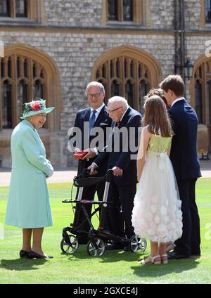 Königin Elizabeth II. (Mit dem Schwert, das ihrem Vater, König George VI., gehörte) verleiht dem 100-jährigen Kapitän Sir Thomas Moore die Ehre der Ritterschaft, bevor er ihm am 17. Juli 2020 bei einer Investiturfeier im Schloss Windsor die Insignien des Knight Bachelor überreicht. Captain Tom Moore hat während der Coronavirus-Pandemie über £32 Millionen für den NHS gesammelt. Stockfoto