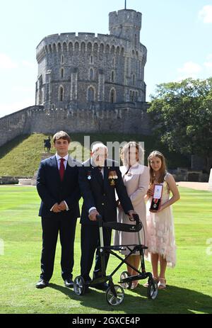 Königin Elizabeth II. (Mit dem Schwert, das ihrem Vater, König George VI., gehörte) verleiht dem 100-jährigen Kapitän Sir Thomas Moore die Ehre der Ritterschaft, bevor er ihm am 17. Juli 2020 bei einer Investiturfeier im Schloss Windsor die Insignien des Knight Bachelor überreicht. Captain Tom Moore hat während der Coronavirus-Pandemie über £32 Millionen für den NHS gesammelt. Stockfoto