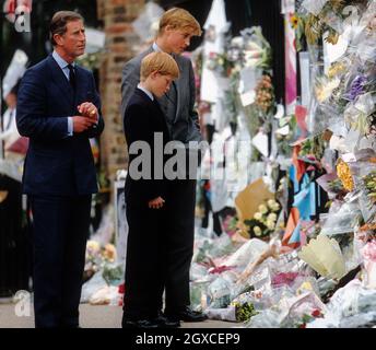 Prinz William, Prinz Harry und Prinz Charles (von links nach rechts) untersuchen die Blumengebete an die verstorbene Prinzessin Diana im Kensington Palace Stockfoto