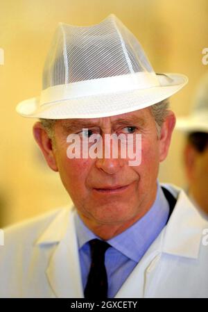 Prinz Charles, Prinz von Wales, trägt einen weißen Hut und Mantel, als er die Küchen des Royal Brompton Hospital in West London besucht. Stockfoto