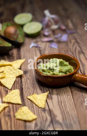 Avocado Dip mit Knoblauch, Chili, Pfeffer und Limettensaft mit Mais Nachos gewürzt Stockfoto
