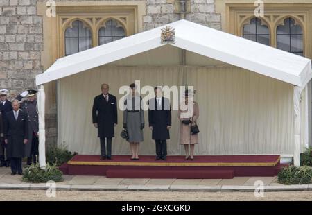 Der französische Präsident Nicolas Sarkozy und seine Frau Carla Bruni-Sarkozy stehen zusammen mit der britischen Königin Elizabeth II. Und Prinz Philip während einer feierlichen Begrüßung im Schloss Windsor in Windsor, Stockfoto