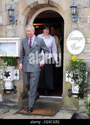 Prinz Charles, Prinz von Wales, spaziert am 31. März 2008 mit Louise Dinnes, Inhaberin des The Black Swan Pub, Restaurants, Hotels und Bars in Ravenstonedale, Cumbria, England. Der Prinz war im Rahmen der Initiative „The Prince's Pub is the Hub“ zu Besuch, um ländliche Gemeinden zu unterstützen und zu fördern. Stockfoto