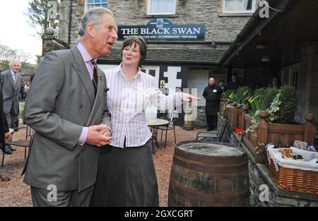 Prinz Charles, Prinz von Wales, spaziert am 31. März 2008 mit Louise Dinnes, Inhaberin des The Black Swan Pub, Restaurants, Hotels und Bars in Ravenstonedale, Cumbria, England. Der Prinz war im Rahmen der Initiative „The Prince's Pub is the Hub“ zu Besuch, um ländliche Gemeinden zu unterstützen und zu fördern. Stockfoto