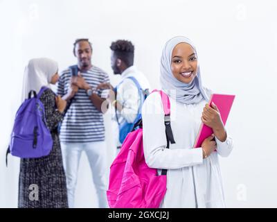 Porträt der jungen afrikanischen Moderne muslimische Studentin mit einer Gruppe von Freunden im Hintergrund das Tragen der traditionellen islamischen hijab Kleidung Stockfoto