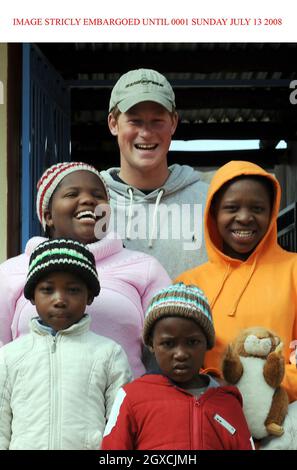 GESPERRT BIS 00.01 SONNTAG, 13. JULI Prinz Harry posiert mit Kindern während eines Besuchs der Lesotho Kinderberatung in Maseru am 9. Juli 2008. Die Fürstenhilfe Sentebale arbeitet mit der LCCU zusammen, um misshandelten Kindern ein sicheres Haus zu bieten. Stockfoto