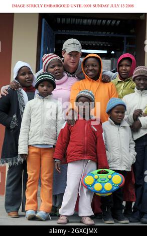 GESPERRT BIS 00.01 SONNTAG, 13. JULI Prinz Harry posiert mit Kindern während eines Besuchs der Lesotho Kinderberatung in Maseru am 9. Juli 2008. Die Fürstenhilfe Sentebale arbeitet mit der LCCU zusammen, um misshandelten Kindern ein sicheres Haus zu bieten. Stockfoto