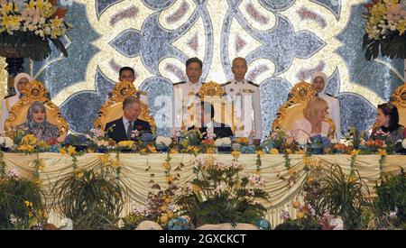 Der Prinz von Wales und die Herzogin von Cornwall sitzen mit Sultan Hassanal Bolkiah und seinen Frauen, Königin Hajah Saleha (L) und Azrinaz Mazhar Hakim (R), während eines königlichen Banketts im Nurul-Iman-Palast in Brunei für einen Teil der königlichen Fernost-Tour. Stockfoto