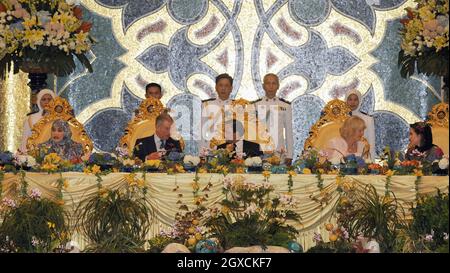 Der Prinz von Wales und die Herzogin von Cornwall sitzen mit Sultan Hassanal Bolkiah und seinen Frauen, Königin Hajah Saleha (L) und Azrinaz Mazhar Hakim (R), während eines königlichen Banketts im Nurul-Iman-Palast in Brunei für einen Teil der königlichen Fernost-Tour. Stockfoto