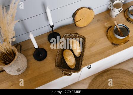 Zwei französische Brötchen in einem Korbkorb auf dem Küchenarbeitsfläche im skandinavischen Stil Stockfoto