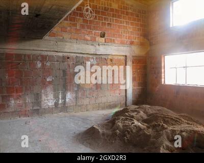 Baustelle Inneneinrichtung der neuen zweigeebenen Wohnung mit Fenstern und roten Ziegelmauern Baustelle im Gange zum neuen Haus Stockfoto