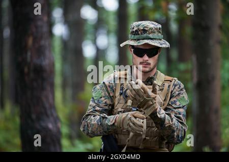 american Marine Corps Spezialoperationen Soldat Vorbereitung taktischen und Communication Ausrüstung für Action-Schlacht Nahaufnahme Stockfoto