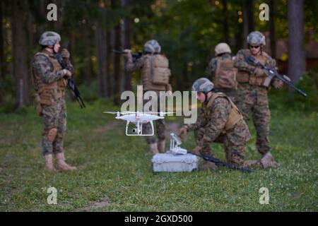 Modern Warfare Soldiers Squad verwenden Drohne für Scouting und Überwachung während der militärischen Operation im Wald. Stockfoto