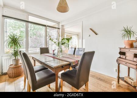 Interieur des gemütlichen Esszimmer mit Holztisch und weichen Ledersesseln in Landhaus im rustikalen Stil gestaltet Stockfoto