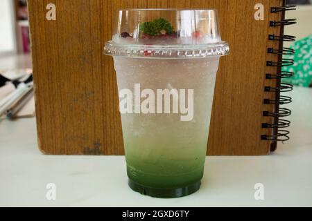 Kiwi Obst Sirup mit Sodawasser Belag rote Beere serviert in Kunststoff-Glas-Tasse für Reisende thai Menschen entspannen Essen und trinken im Restaurant Café Stockfoto