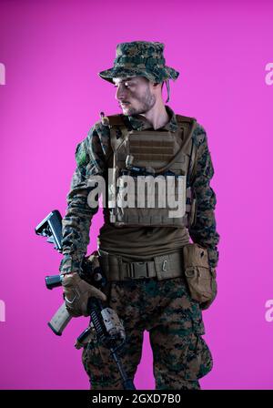 American Marine Corps Special Operations Modern Warfare Soldat mit Feuer arm Waffe und schützenden Armee taktische Ausrüstung bereit für den Kampf auf Rosa hinterg Stockfoto