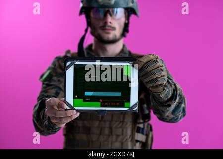 Soldat mit einem Tablet-PC mit der Fehlermeldung auf dem Bildschirm auf rosa Hintergrund isoliert Stockfoto