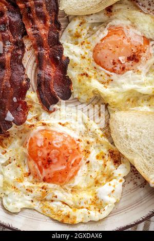 Leckere, sonnige Eier mit gebratenem Speck auf dem Teller Stockfoto