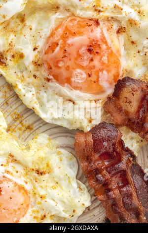 Leckere, sonnige Eier mit gebratenem Speck auf dem Teller Stockfoto