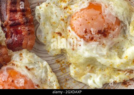 Leckere, sonnige Eier mit gebratenem Speck auf dem Teller Stockfoto