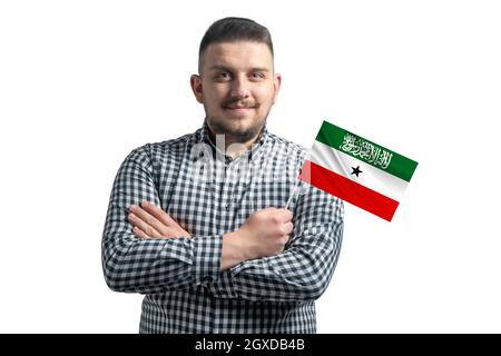 Weißer Mann mit einer Flagge von Somaliland lächelnd zuversichtlich mit gekreuzten Armen isoliert auf weißem Hintergrund. Stockfoto