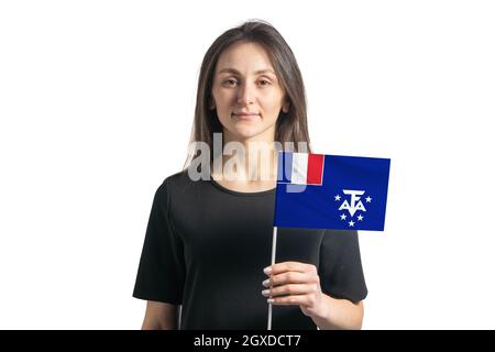 Glückliches junges weißes Mädchen, das die Flagge der französischen Süd- und Antarktisgebiete auf weißem Hintergrund isoliert hält. Stockfoto