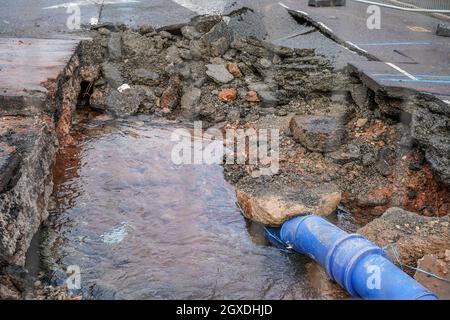 Kidderminster, Großbritannien. Oktober 2021. Eine geplatzte Wasserleitung hat heute Morgen in Kidderminster zu erheblichen Verkehrsstörungen geführt. Der Combertion Hill Highway, der zum Bahnhof Kidderminster führt, wurde aufgrund von Reinigungsarbeiten und Reparaturen gesperrt. Ein Zuschauer, der gestern Abend die geplatzte Wasserleitung sah, sagte, die Straße sah aus, als ob sie schwebte und begann dann einzustürzen, während der Verkehr zu der Zeit weiter über sie fuhr. Die gesamte Oberfläche der Straße hat sich angehoben, ebenso der Fußweg, durch den noch immer Wasser tropft. Kredit: Lee Hudson/Alamy Live Nachrichten Stockfoto