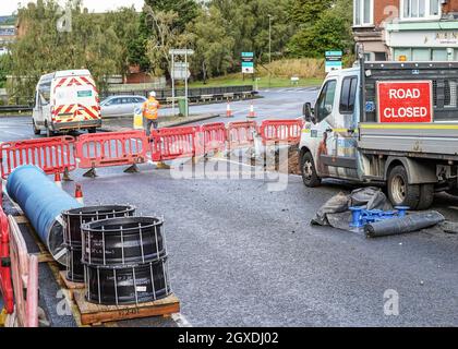 Kidderminster, Großbritannien. Oktober 2021. Eine geplatzte Wasserleitung hat heute Morgen in Kidderminster zu erheblichen Verkehrsstörungen geführt. Der Combertion Hill Highway, der zum Bahnhof Kidderminster führt, wurde aufgrund von Reinigungsarbeiten und Reparaturen gesperrt. Ein Zuschauer, der gestern Abend die geplatzte Wasserleitung sah, sagte, die Straße sah aus, als ob sie schwebte und begann dann einzustürzen, während der Verkehr zu der Zeit weiter über sie fuhr. Die gesamte Oberfläche der Straße hat sich angehoben, ebenso der Fußweg, durch den noch immer Wasser tropft. Kredit: Lee Hudson/Alamy Live Nachrichten Stockfoto