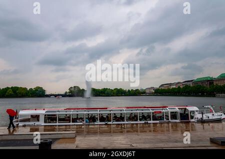 Blick auf die Binnenalster oder die Binnenalster mit Alsterbrunnen in Hamburg. Passagiere im Boot. Regentag. Hamburg, Deutschland, 08. Mai 2014 Stockfoto