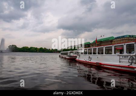 Blick auf die Binnenalster oder die Binnenalster mit Alsterbrunnen in Hamburg. Zwei leere Boote parkten. Regentag. Hamburg, Deutschland, 08. Mai 2014 Stockfoto