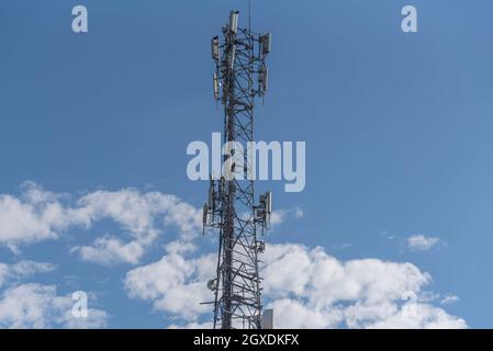 Mobilfunkdatenübertragungsturm auf blauem, natürlichem Hintergrund. Kommunikationsinfrastruktur für die Datenübertragung. Natürliche Landschaft. Metallstruktur. Stockfoto