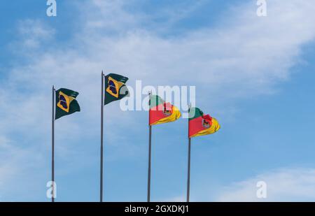 Flaggen des Bundesstaates Rio Grande do Sul und Brasilien auf blauem Naturhintergrund. Offizielle Symbole des brasilianischen Staates Rio Grande do Sul und Brasilien Stockfoto