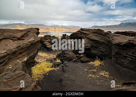 Vulkanische Felsformation in der Nähe von Dyrholaey an einem bewölkten Tag, Island Stockfoto
