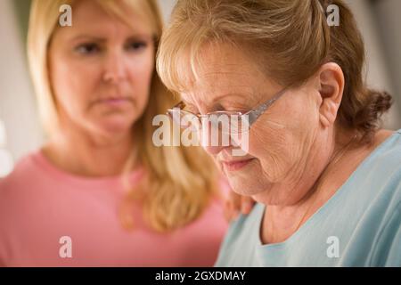 Junge Frau tröstet traurige Senior Erwachsenfrau. Stockfoto