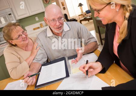 Senior paar Papiere in ihrer Heimat mit Agent durchgehen. Stockfoto