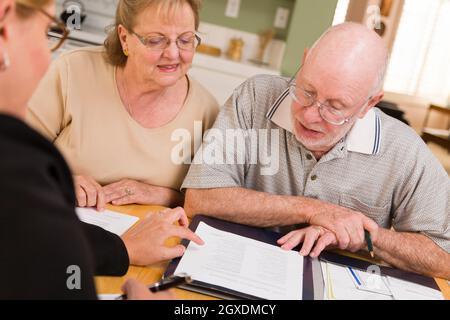 Senior paar Papiere in ihrer Heimat mit Agent durchgehen. Stockfoto