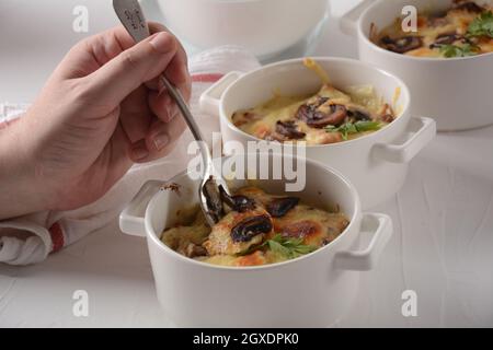 Julienne mit Huhn und Pilzen mit einer goldenen Kruste, gebackenem Käse Stockfoto