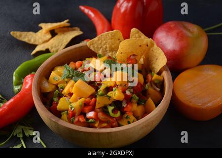 Salsa mit Mango, Kräutern, Zwiebeln und Paprika, Mais-Chips schließen in einer Schüssel. Mexikanisches Essen. Stockfoto