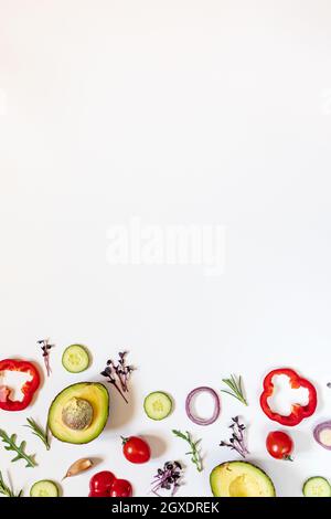 Kreatives Layout von Tomaten, Gurken, Paprika, Avocados und Salaten. Flach legen. Food-Konzept. Platz für Ihren Text. Stockfoto