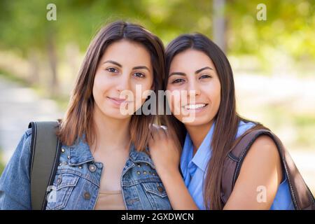 Junge Erwachsene Mischlinge Twin Sisters Portrait tragen Rucksäcke außerhalb. Stockfoto