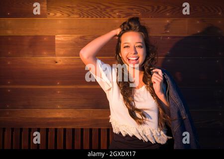 Porträt von eine ziemlich Gemischte Rassen junge Frau vor dem Hintergrund der glänzenden Holzwand. Stockfoto