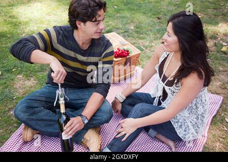 Attraktives hispanische paar mit einem Picknick im Freien im Park. Stockfoto