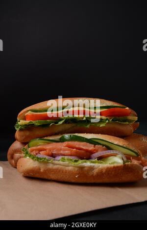 Baguette Sub Sandwich mit Lachsfisch, Zwiebeln, Gurken, Salat Stockfoto