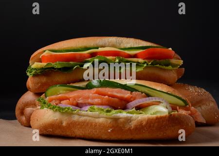 Baguette Sub Sandwich mit Lachsfisch, Zwiebeln, Gurken, Salat Stockfoto